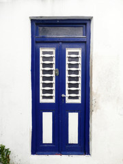 Blue door on white wall on a Greek island