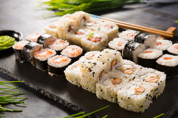Set of sushi rolls with wasabi and ginger on a black background. Japanese oriental cuisine