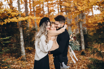 Stylish family in the autumn forest. Models. A young guy and a girl stand on a forest road among...