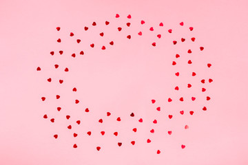 pink background with heart shaped confetti and copy space
