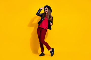 Fototapeta na wymiar Full length photo of carefree crazy girl in red clothes spring shoes screaming yeah isolated over bright yellow background