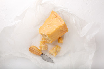 Piece of parmesan cheese on white background. Parmigiano Reggiano, hard mature cheese.