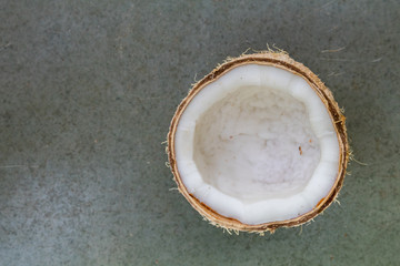 top view of a half cut coconut on plain background