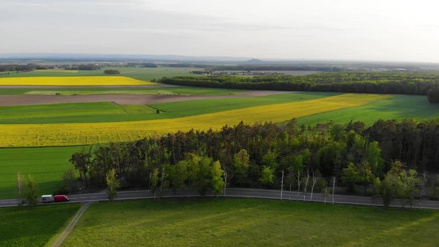 beautiful view of the landscape with forest, fields, meadows and a road with moderate traffic agricultural area in central europe, quiet life in the countryside