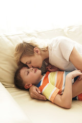 Lovely mother and son in embrace at home