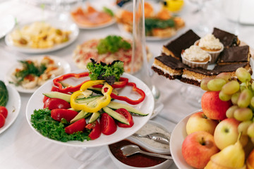 Food on the table, yellow and red chopped peppers next to the cake