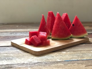 Fresh Watermelon on wood plank,sliced with triangle like christmas tree,dimly light,selective focus.Fruit for summer time.