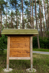 eine Holztafel steht im Wald