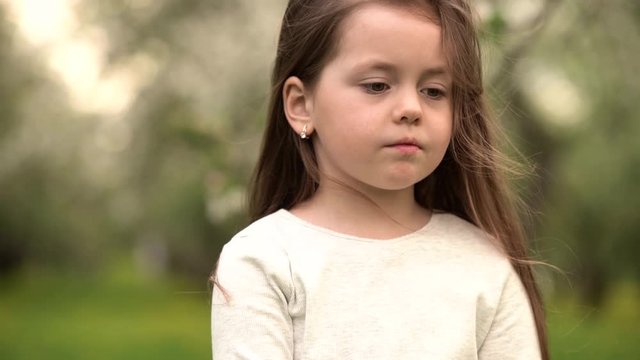 portrait beautiful little girl smiling looking happy cute child having fun in sunny park outdoors, enjoying childhood. 4k footage