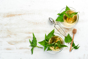 Nettle tea in cups on a white background. Herbal healthy drinks. Top view. Free space for your text.