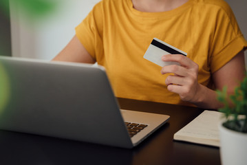 Fototapeta premium Hands holding credit card and using laptop. Online shopping