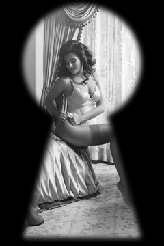 Watching through the keyhole on woman wearing lingerie