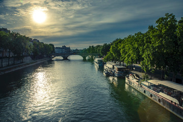 Paris, France - May 12, 2020: End of the day by the Seine. Reflection of the sun on the barges