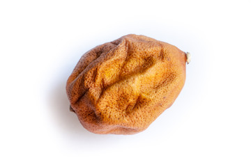 old wrinkled lemon on a white background, lemon skin - dried, with dark spots, unappetizing in appearance