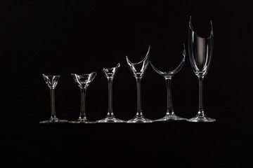 broken sharp transparent glasses in row isolated on black