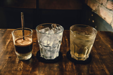 Vietnamese Milk Coffee on Wooden Table. Traditional Hot Drinks in Vietnam. Close-up Vietnamese Drip Coffee and Ice mug served with milk, Iced black coffee.