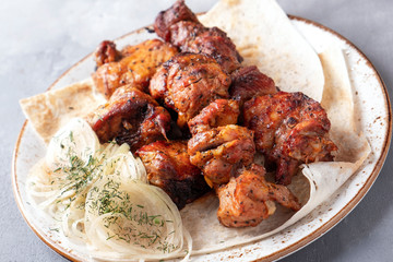 Pork shish kebab with onion on a plate. Bbq pork meat on a plate. Shashlik