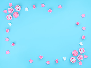Fototapeta na wymiar Pink and white flowers made of foamiran on blue background with beads. Mother day, Valentine day, Wedding, Birthday concept. Greeting or invitation card. Flat lay with copy space.