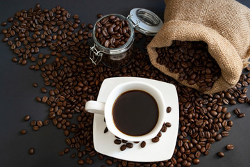 Scattered coffee beans and black coffee makes. Decorative coffee sacks look perfect in this combination