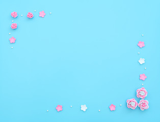 Fototapeta na wymiar Pink and white flowers made of foamiran on blue background with beads. Mother day, Valentine day, Wedding, Birthday concept. Greeting or invitation card. Flat lay with copy space.