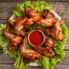 Barbecue chicken wings with red sauce. Rustic style. Top view, closeup