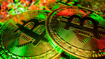 2 most popular crypto coins in the world. Bitcoin in green and red light with reflection
