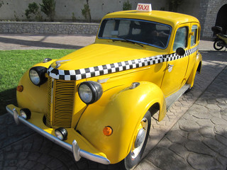 Vintage yellow taxi with checkers in the Park in summer