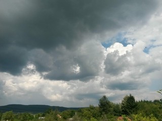 Fototapeta na wymiar stormy clouds over green forest in summer season