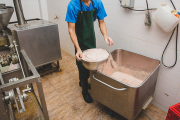 Ground pork in a stainless steel tank to be used as meatballs.