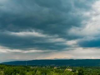 stormy clouds over green forest in summer season