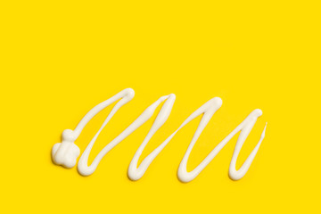 Crema para el cuerpo sobre un fondo amarillo liso asilado y brillante. Vista superio. Copy space