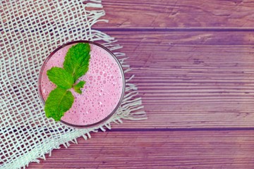 Strawberry smoothie yogurt served in a glass on wooden table.