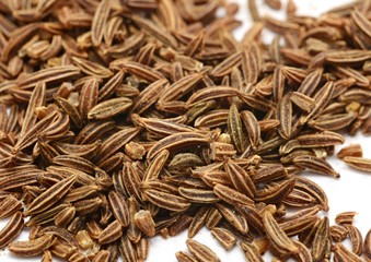 Caraway seeds on white background.