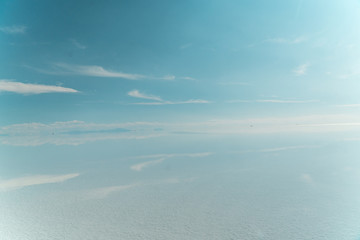 Fototapeta na wymiar Blue Sky Clouds Mirror Reflection. Cloud Sky reflect on water surface of Bolivia's Salt Flats. Empty space in landscape. Holiday, vacation, freedom scene with horizon. Salar de Uyuni salt flat