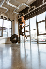 Obraz na płótnie Canvas Brunette sportswoman in sportswear jumping in sports center