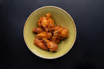 fried chicken legs in a plate on a dark background