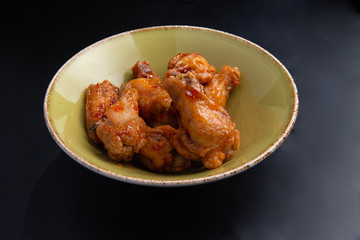 fried chicken legs in a plate on a dark background