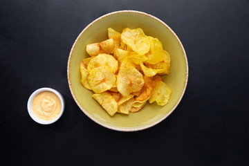 potato chips and sauce on a dark background