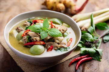 Thai food, Green curry with pork (Kang Keaw Wan) in a bowl with ingredients on wooden background