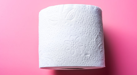 Toilet paper on pink light background.