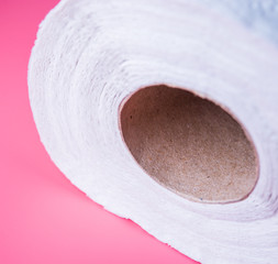 Toilet paper on pink light background.