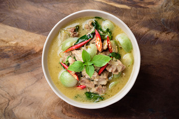 Thai food, Green curry with pork (Kang Keaw Wan) in a bowl on wooden background, Top view