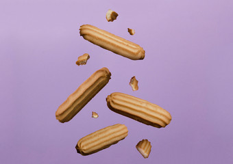 Falling tasty biscuits and pouring milk against pink background.Concept of delicious breakfast
