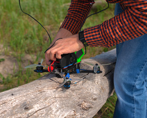 man repairs and adjusts a racing drone before flying - Powered by Adobe