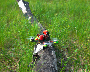 multicolored racing drone on grass background