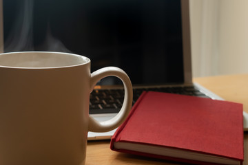 Grey smoking cup with a notebook and a working computer