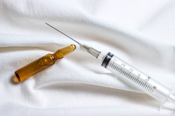 Medicine concept. Photo from above and on a white background. A medical syringe and a vaccine...