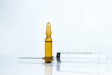 Medicine concept. Photo on a white background. Injection vial and syringe on a glass surface