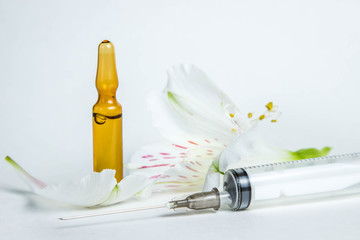 The concept of medicine and beauty. Photo on a white background. Next to each other are an ampoule...