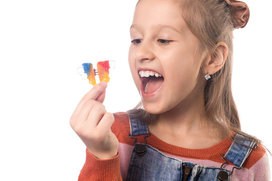 Little girl with orthodontics appliance isolated on white background.